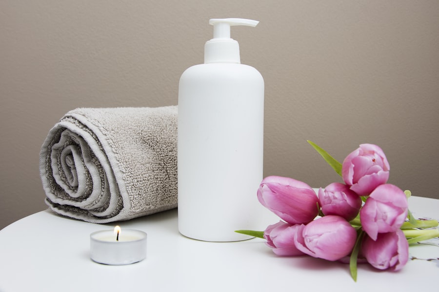 Set benessere da SPA: asciugamano arrotolato, olio e tulipani rosa